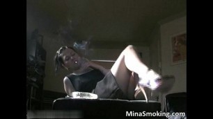 Sexy brunette babe smokes a cigarette